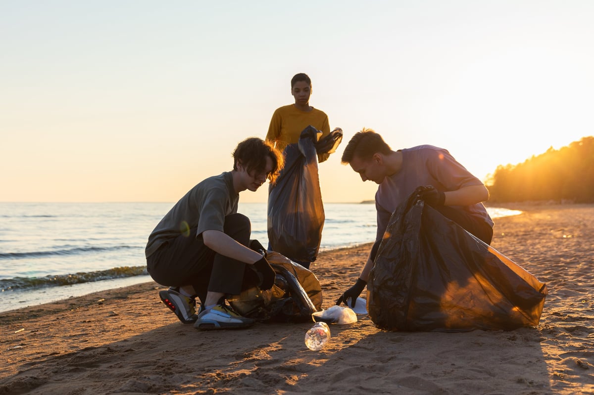 Volunteers collecting garbage on beach for environmental conservation