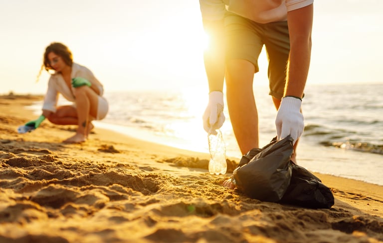 Cleanup garbage on the ocean coast with volunteers picking up plastic bottle