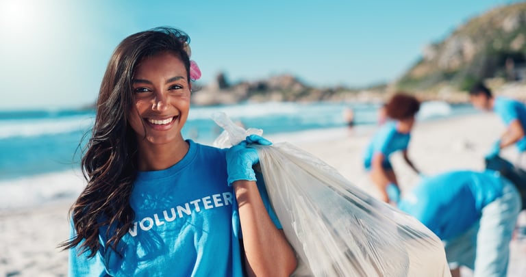 Volunteer woman with bag for cleaning dirt, plastic and litter for ocean pollution