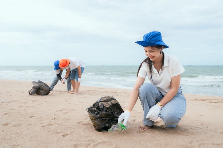 A group of volunteers works together to remove plastic trash from the sandy beach