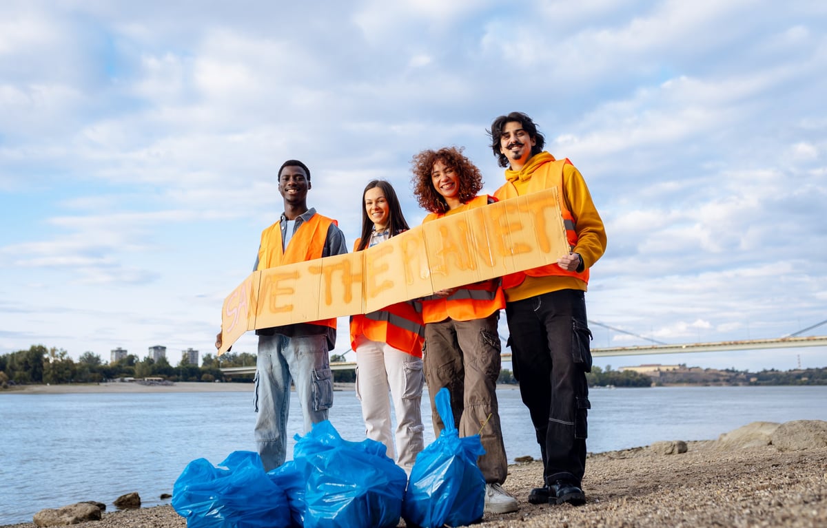 Group of volunteers holding Save the Planet sign during cleanup